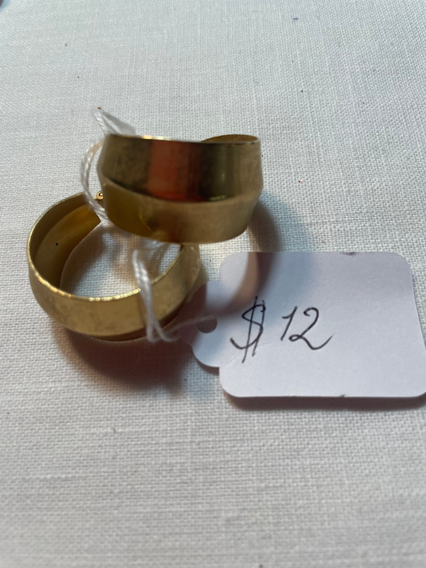 A pair of golden hoop earrings, clip on